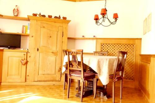 une salle à manger avec une table, des chaises et un lustre dans l'établissement Appartement avec jardin à Crans-Montana, à Crans-Montana
