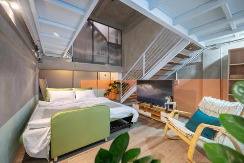 Schlafzimmer mit einem Bett, einem TV und einem Stuhl in der Unterkunft MIQ Ekkamai2 3BR Designer home Oval Bathtub 15pax in Bangkok
