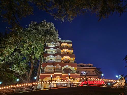 シムラーにあるHotel Taj Palace near Mall Roadの夜間照明付きの高層ビル