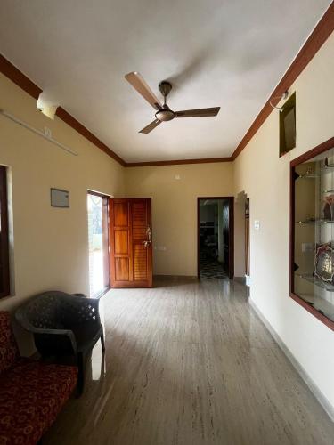 an empty living room with a ceiling fan at Sri sai home Stay in Udupi