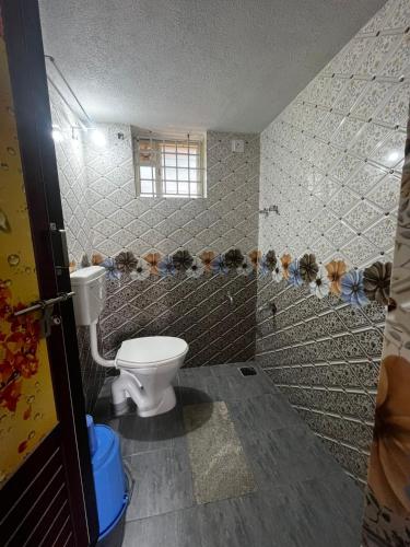 a bathroom with a toilet and a window at Sri sai home Stay in Udupi