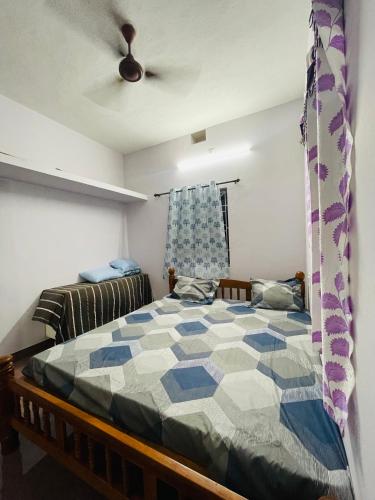 1 dormitorio con 1 cama y ventilador de techo en Sri sai home Stay, en Udupi