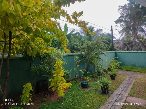 a garden with a fence and trees and plants at Villa Tanzanite Hikkaduwa in Hikkaduwa