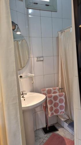 a small bathroom with a sink and a mirror at La buena vida. in Málaga