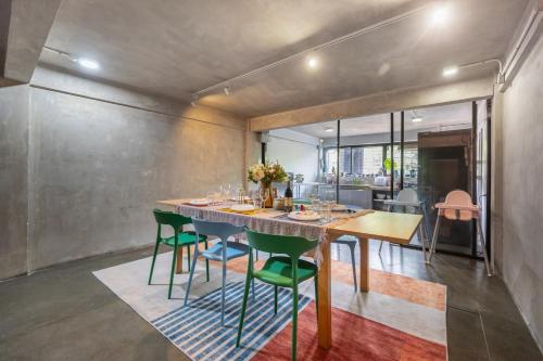 a dining room with a table and green chairs at MIQ Ekkamai2 3BR Designer home Oval Bathtub 15pax in Bangkok