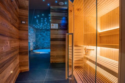 eine Sauna mit Badewanne in einem Zimmer mit Holzwänden in der Unterkunft Ca' Leonardi - Valle di Ledro in Ledro