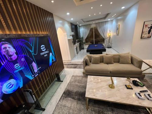 a living room with a couch and a large screen tv at بيت النرجس الخاص in Riyadh