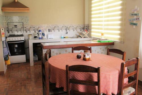 a kitchen with a table and a kitchen with a stove at Lago Sagrado Titicaca - Casa de Campo & Agroturismo in Huayllara