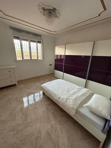 Schlafzimmer mit einem Bett und einem Kronleuchter in der Unterkunft Villa Assia with view on the Ocean and Mountains 