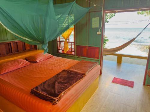 un lit dans une chambre avec un hamac dans l'établissement Sawasdee Resort, à Koh Chang Ranong