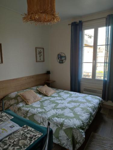 1 dormitorio con 2 camas y ventana en Charmant studio 8, parking et wifi gratuit, arrêt navette, en Bagnoles de l'Orne