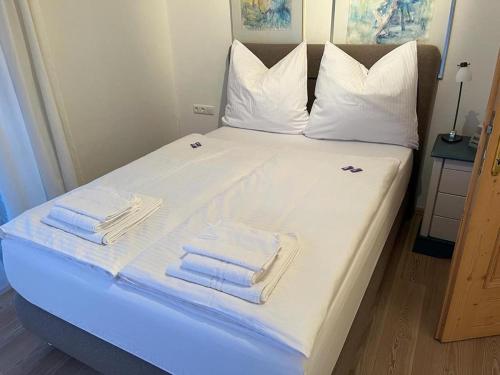 ein Bett mit weißer Bettwäsche und Handtüchern darauf in der Unterkunft Berghaus in Ellmau