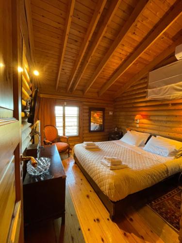 a bedroom with a bed in a wooden cabin at Villa Marrone Splendid Seaview in Markópoulon Oropoú