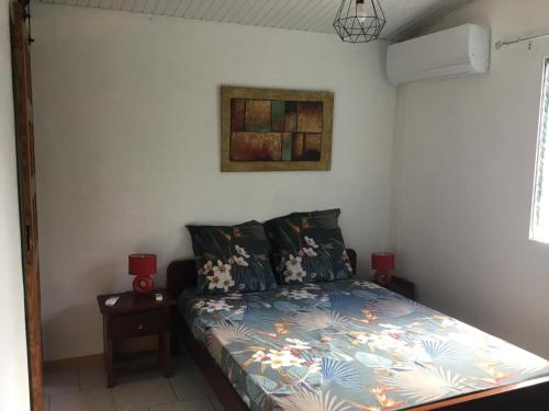 ein Schlafzimmer mit einem Bett mit einer bunten Bettdecke in der Unterkunft Noukatchimbe Bungalow avec piscine partagée pour 2 à 4 personnes in Le Marin
