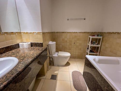 Silvana Deluxe Hostel في دبي: حمام مع مرحاض وحوض استحمام ومغسلة