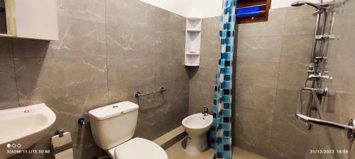 a bathroom with a toilet and a sink at Villa Tanzanite Hikkaduwa in Hikkaduwa