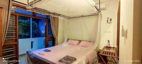 a bedroom with a canopy bed in a room at Villa Tanzanite Hikkaduwa in Hikkaduwa