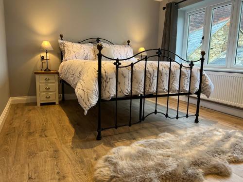 a bedroom with a black bed with a rug at Shepherd's Cottage in Totland