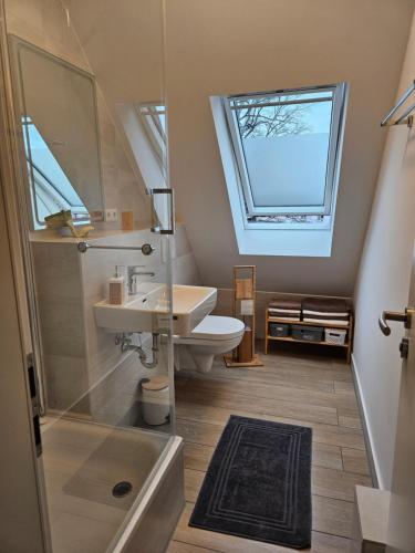 ein Bad mit einem Waschbecken, einem WC und einem Fenster in der Unterkunft 3 Zimmerwohnung am Neuer Teich in Wolfsburg