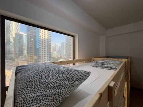 a room with a bed with a large window at Silvana Deluxe Hostel in Dubai