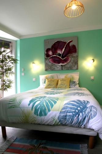 - une chambre avec un lit orné d'une peinture florale sur le mur dans l'établissement GREEN SPA Sauna Balneo Centre Agen, à Agen