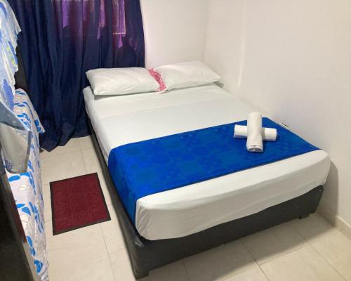 uma pequena cama num quarto com um azul e branco em RED HOUSE 47 em Cartagena de Indias