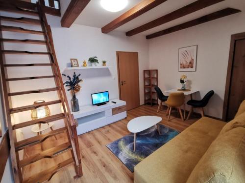 uma sala de estar com um sofá, uma televisão e uma mesa em Apartmánový dom Fatrapark 1- Ap 318, Ap 306 Mezonet em Ruzomberok