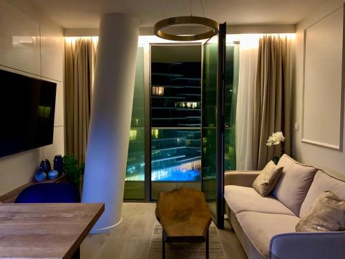 uma sala de estar com um sofá e uma mesa em Blue Reef 6th Floor Sea View Miedzyzdroje em Międzyzdroje