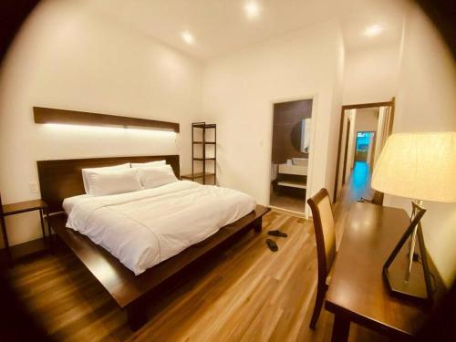 sypialnia z łóżkiem, biurkiem i lampką w obiekcie Fa's House Hue w mieście Thôn Kim Long (1)
