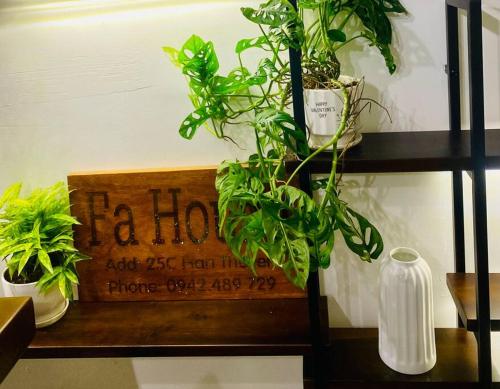 a wooden sign on a shelf with plants on it at Fa's House Hue in Thôn Kim Long (1)