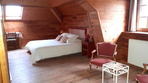 a bedroom with a bed and a chair in a room at Domaine de Montvianeix in Saint-Victor-Montvianeix