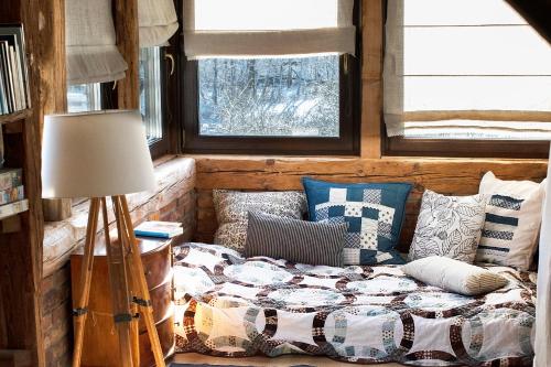 Cama en habitación con almohadas y lámpara en Dom W Trawie en Drawsko Pomorskie