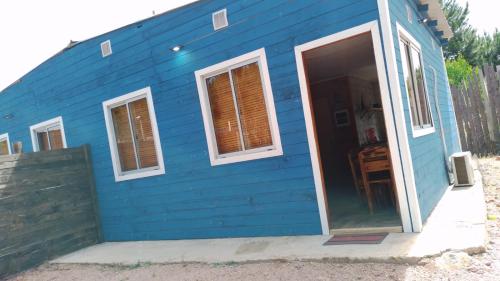 a blue house with a door and windows at Cabañas azules in Punta Del Diablo