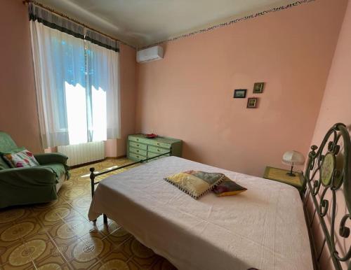 een slaapkamer met een bed, een bank en een raam bij La Terrazza in Pietrasanta