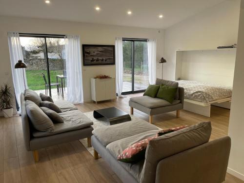 un salon avec un canapé et un lit dans l'établissement Maison rénovée en Bourgogne - Renewed house in Burgundy, à Talcy