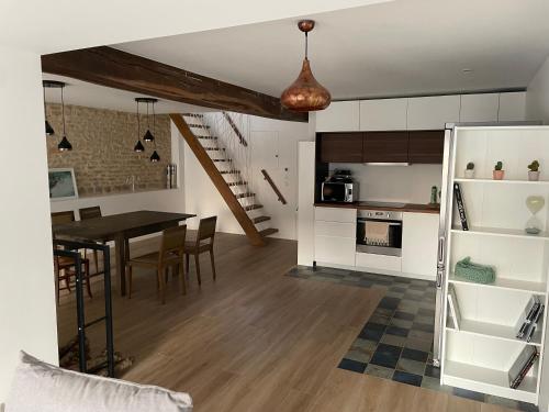 une cuisine et une salle à manger avec une table et une salle à manger dans l'établissement Maison rénovée en Bourgogne - Renewed house in Burgundy, à Talcy