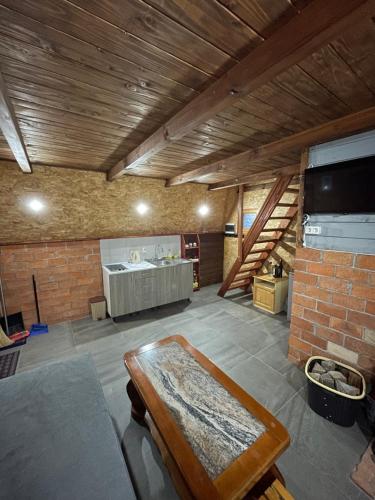 uma sala de estar com uma mesa e uma parede de tijolos em Casa Lidija em Kupres
