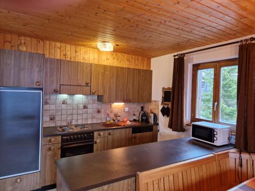 cocina con armarios de madera y encimera en Les RHODOS 3 en Les Crosets
