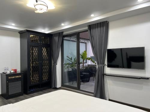 a living room with a tv and a bed at Lotus Hotel Ninh Bình in Ninh Binh
