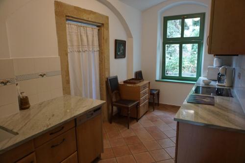 cocina con encimera y silla en Ferienwohnung Villa Barbara auf der sächsischen Weinroute, en Radebeul