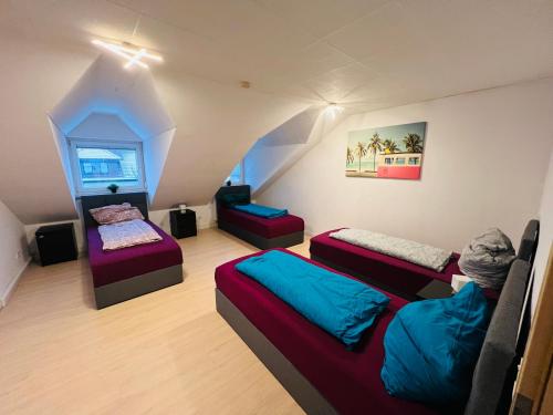 um quarto com 3 camas num sótão em Generous Apartment with own parking Space em Paderborn