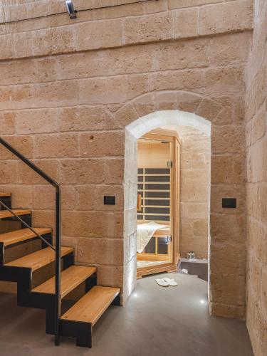 a room with a brick wall and a staircase at Hydria Rooms in Matera