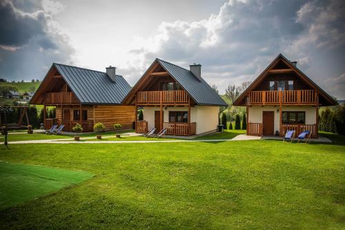 ein Haus mit einem grünen Rasen davor in der Unterkunft Domki w Bieszczadach Nova Dolina in Średnia Wieś