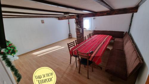 a dining room with a red table and chairs at Къща за гости Коларски in Sapareva Banya