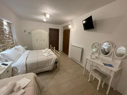 a bedroom with a bed and a sink and a mirror at B&B I Giardini in Pieve Torina