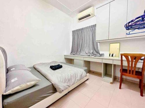 a bedroom with a bed and a desk with a chair at TAMAN UNIVERSITI THREE BEDROOMS 6-10Pax UTM, SKUDAI in Skudai