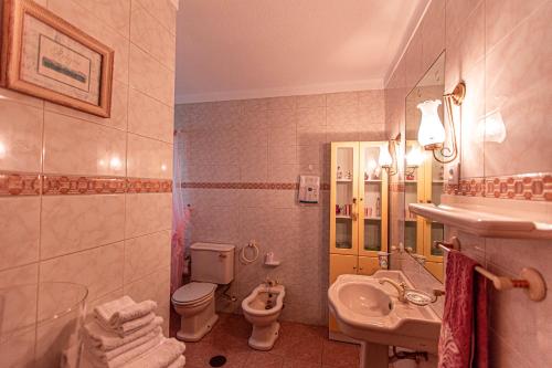 een badkamer met een wastafel, een toilet en een wastafel bij Quinta da Xistosa - Wonderland X in Foz do Sousa
