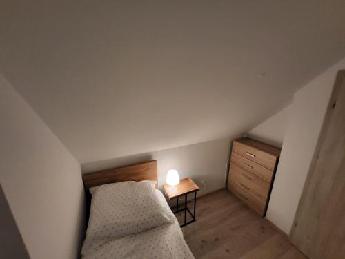 małą sypialnię z łóżkiem i szafką nocną w obiekcie Sosnowe Wzgórze - Wypoczynek w Zagórzu Śląskim 2 w Zagórzu Śląskim