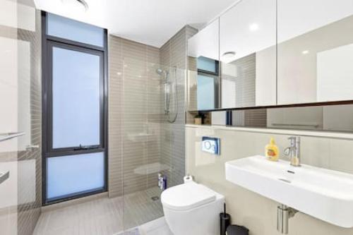 een badkamer met een toilet, een wastafel en een raam bij comfy 2B apartment in Zetland in Sydney