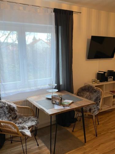 a table and chairs in a room with a window at Kuschelnest Michelstadt in Michelstadt